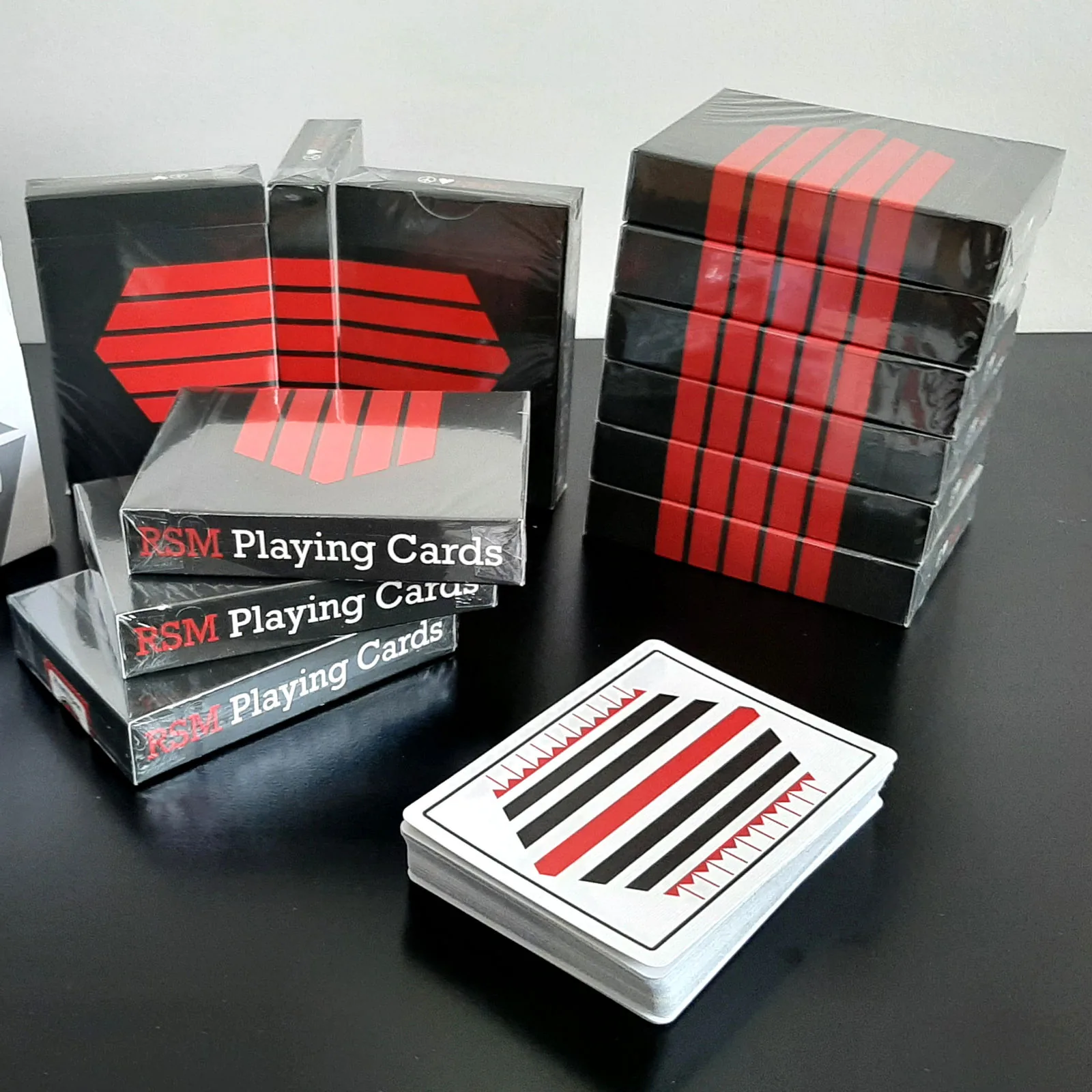 Stacks of Pinstripe Playing Cards boxes in black and red