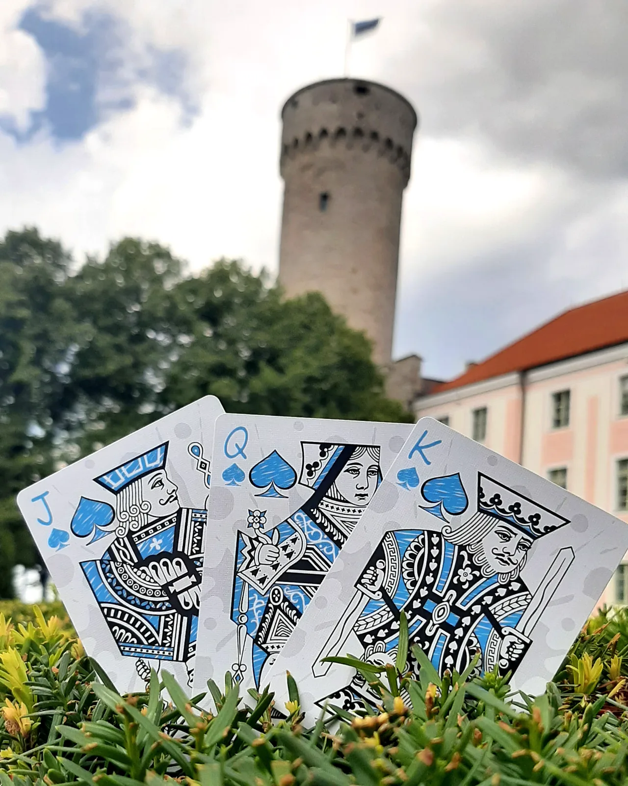 Inkwell court cards held up in front of Tall Hermann tower in Tallinn