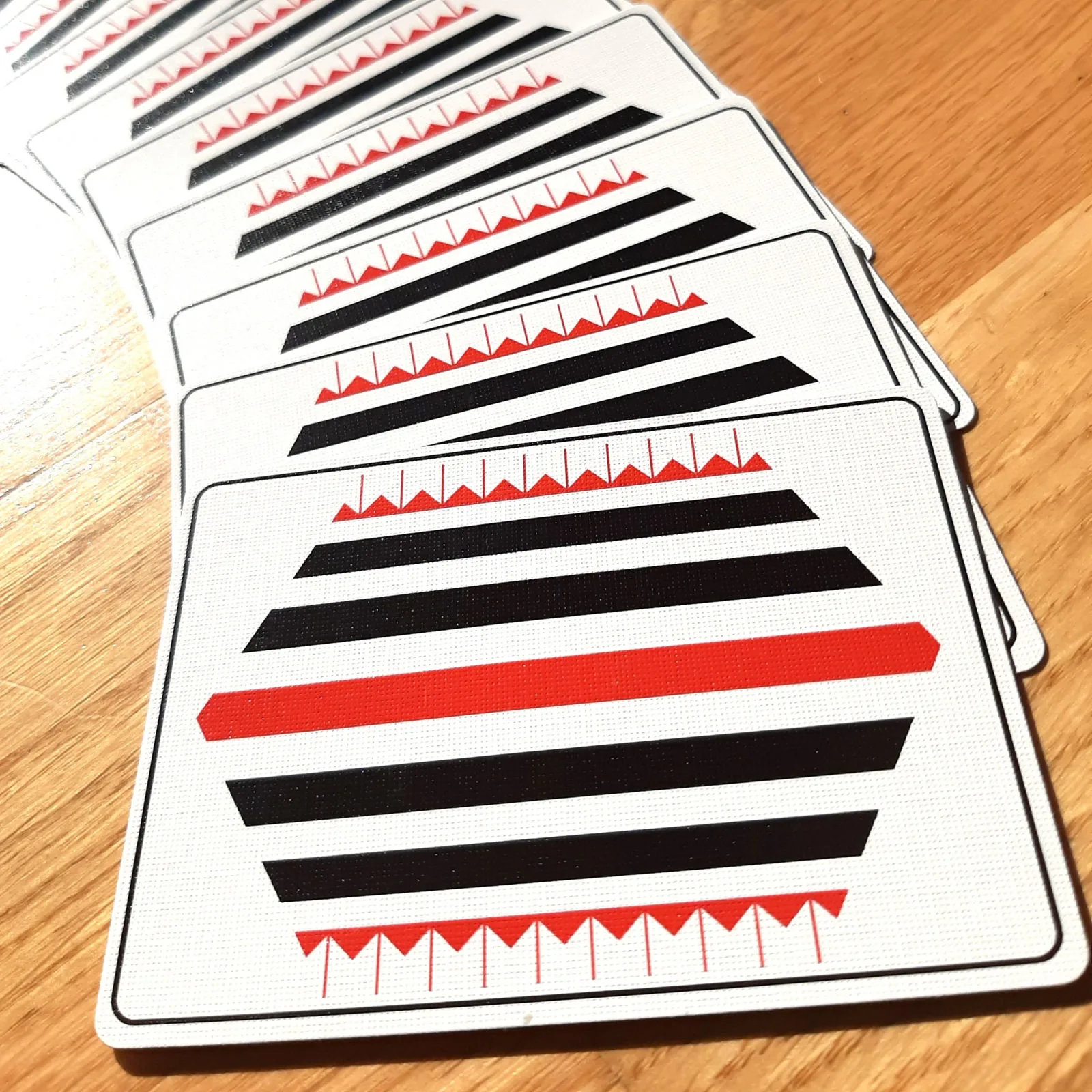 Pinstripe card backs fanned across a wooden table