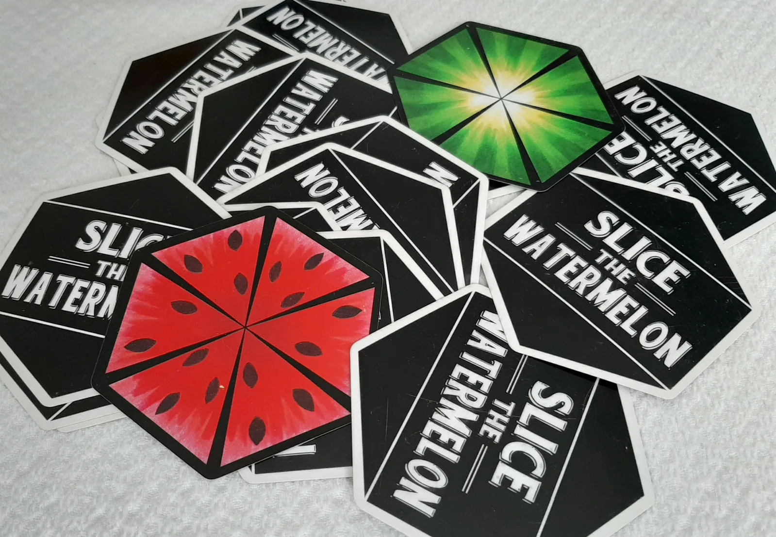 Tiles face up and face down, showing the watermelon front and black logo back