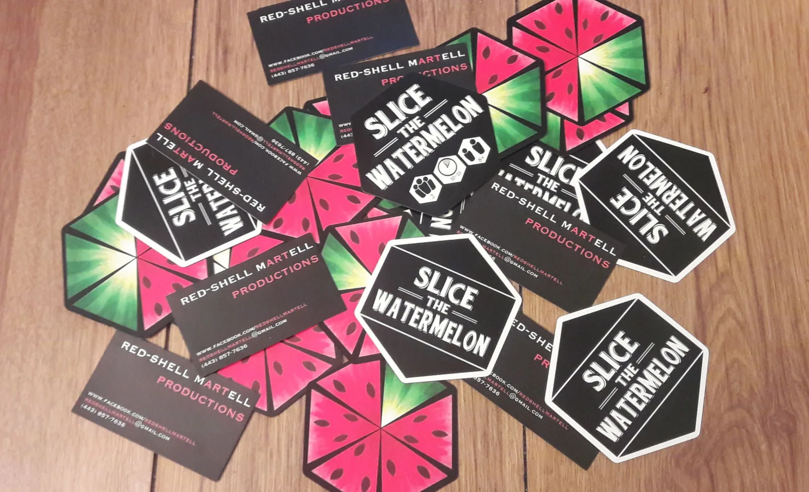 Game packs, tiles and business cards spread on a wooden table